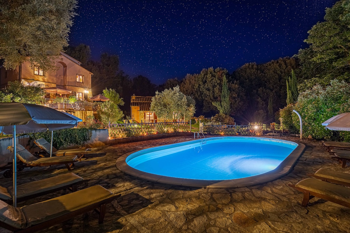 La piscina di Pian delle More di notte, illuminata tra gli alberi